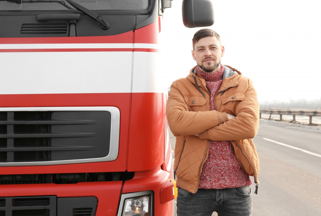 Trucker next to his truck on a highway