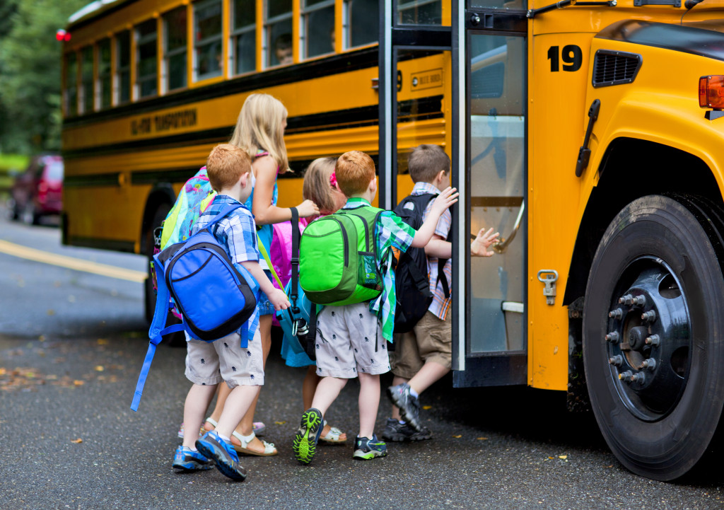 children hopping on the school bus