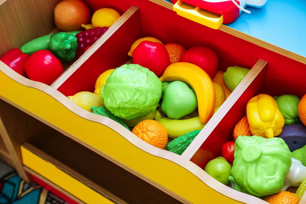 toy fruits and vegetables in a play grocery store setting